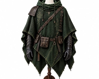 Pode incluir: Um poncho com capuz verde-escuro com bainha desfiada, uma ombreira texturizada e um cinto utilitário de couro castanho com várias bolsas. A peça inclui uma alça diagonal no peito e luvas de couro preto nos braços.