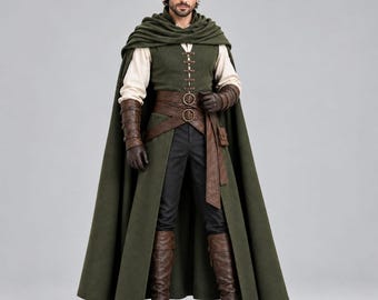 Pode incluir: Uma capa com capuz verde-oliva escuro sobre uma camisa de manga comprida creme e um colete verde-oliva escuro com atacadores frontais. O traje inclui um cinto largo de couro castanho com fivelas duplas, braçadeiras de couro e botas castanhas.