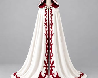 Pode incluir: Uma capa branca com capuz até ao chão, com acabamento em veludo vermelho escuro ao longo das bordas frontais, da bainha e do interior do capuz. A peça é presa ao pescoço com um fecho metálico e apresenta um padrão contínuo de videiras.