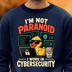 May include: A navy blue crewneck sweatshirt featuring a graphic of a yellow rubber duck wearing sunglasses, sitting at a laptop with a padlock icon. The text reads I'M NOT PARANOID I WORK IN CYBERSECURITY and SECURITY FUELED BY COFFEE.
