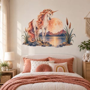 Könnte beinhalten: Ein Wandaufkleber mit einem weißen Einhorn mit langer, fließender orangefarbener Mähne und Schweif, das auf Felsen an einem See steht. Die Szene zeigt einen großen orangefarbenen Vollmond, ferne Berge und hohe Rohrkolben an beiden Ufern.