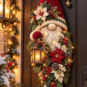 Puede incluir: Un adorno de puerta de ganchillo con forma de gnomo, con un gorro rojo alto con cascabel dorado, barba color crema y una linterna. La pieza está decorada con flores de pascua tejidas, ramas de pino, piñas y bayas rojas, iluminada por pequeñas luces LED cálidas.