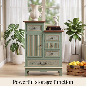 May include: A sage green wooden storage cabinet with a dark wood top, featuring one large door with vertical slats, four drawers with ornate metal pulls, and decorative scrollwork. The text "Powerful storage function" is printed below.