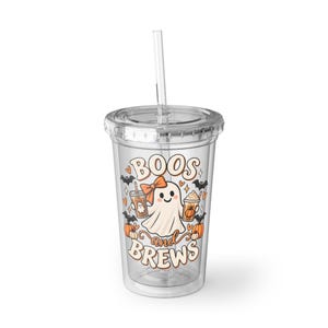 Puede incluir: Un vaso de plástico transparente con tapa y pajita que presenta un gráfico de un fantasma con un lazo naranja, sosteniendo dos tazas de café, rodeado de calabazas, murciélagos y corazones, con el texto BOOS and BREWS en fuente retro.