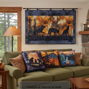 May include: A rectangular wall hanging featuring a silhouette of three wolves against a fiery orange and dark blue forest background, suspended from a black rod. The textile art displays a detailed scene of wildlife in a natural environment.