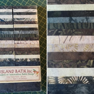 May include: A fabric strip pack with various shades of green, brown, and white. The pack contains 40 strips, each 2.5 inches wide, with 20 different designs. The label reads "ISLAND BATIK Inc. Leaders in Innovative Batik Design."