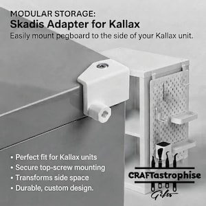 May include: A white plastic Skadis adapter for Kallax units featuring a top-screw mounting mechanism. The text reads: MODULAR STORAGE: Skadis Adapter for Kallax. Easily mount pegboard to the side of your Kallax unit. Perfect fit for Kallax units. Secure top-screw mounting. Transforms side space. Durable, custom design. CRAFTastrophise Gifts.