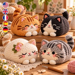 May include: Four crocheted cat plushies in various colors including orange tabby, black and white, cream with a pink flower, and grey tabby. Each cat features embroidered facial details, small pink ears, and white paws, arranged on a wooden surface.