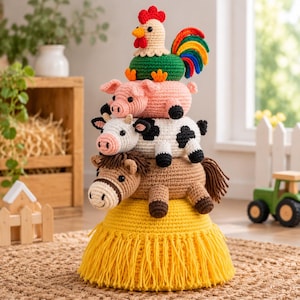 May include: A vertical stack of five crocheted farm animal figures. From bottom to top: a yellow hay bale base with fringe, a brown horse, a black and white cow, a pink pig, and a colorful rooster with a red comb and a rainbow-colored tail.