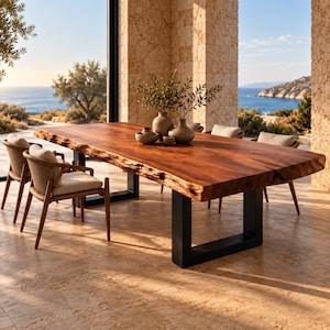 Puede incluir: Una gran mesa de comedor rectangular con un tablero de madera maciza de borde natural y dos patas de metal negro en forma de U. La mesa está rodeada por cuatro sillas con respaldos trenzados y cojines beige claro. Dos jarrones de cerámica con follaje.