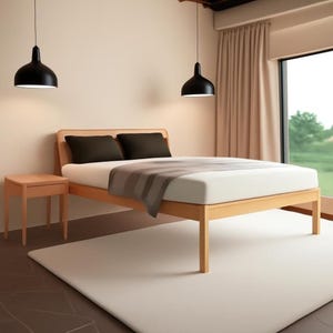 Può includere: Una struttura letto in legno chiaro con un materasso bianco, una coperta grigia e due cuscini marrone scuro. Accanto al letto si trova un comodino abbinato in legno chiaro. Due lampade a sospensione nere a forma di cupola pendono dal soffitto.