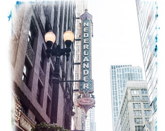 May include: A vintage-style photo of a building with a sign that reads "Nederlander Chicago" and a street lamp in front of it. The building is a theater with a marquee that reads "Paradise Square".