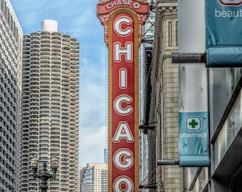 May include: A red and gold sign with the word "CHICAGO" in large letters. The sign is attached to a building with a white facade. The building has a pharmacy sign and a beauty supply store sign. The sign is lit up and has a vintage look.
