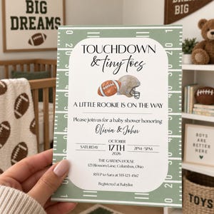 Puede incluir: Una tarjeta de invitación rectangular para baby shower con un borde de campo de fútbol americano en color verde salvia. El texto dice TOUCHDOWN & tiny toes, A LITTLE ROOKIE IS ON THE WAY, Olivia & John, sábado 17 de octubre de 2026, 14h-17h.
