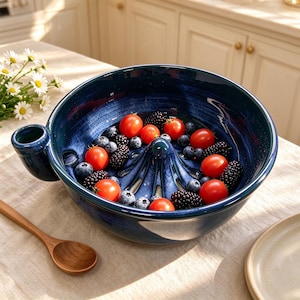May include: A deep blue ceramic citrus juicer bowl with a central reamer and a side handle, filled with fresh red cherry tomatoes, dark blackberries, and small blueberries. The bowl features a glossy, mottled finish with lighter blue streaks.