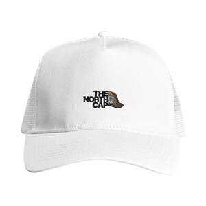 Könnte beinhalten: Eine weiße Trucker-Cap mit Netzrückseite und festem Vorderteil. Auf der Vorderseite ist der schwarze Schriftzug THE NORTH CAP eingestickt, wobei rechts neben dem Schriftzug eine kleine braun-weiße Berggrafik integriert ist.