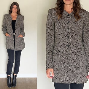 May include: A long-sleeved black and white patterned blazer with a button-up front and two pockets.