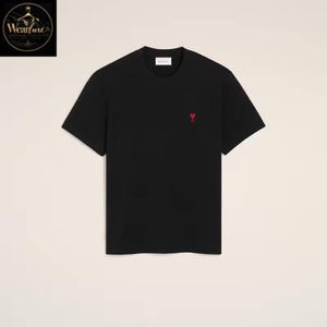 May include: A black short-sleeved t-shirt featuring a crew neckline and a small red heart-shaped logo embroidered on the left chest area. The garment has a straight hemline and a clean, solid-colored design throughout the front of the piece.