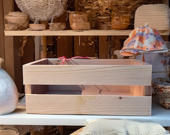 Peut inclure: Une caisse en bois clair avec un seul séparateur, posée sur une étagère blanche. La caisse est vide et prête à être remplie.