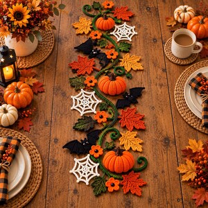 Könnte beinhalten: Ein langer, gehäkelter Halloween-Tischläufer mit orangefarbenen Kürbissen, weißen Spinnennetzen, schwarzen Fledermäusen und bunten Herbstblättern, die durch grüne Ranken verbunden sind, auf einer Holzoberfläche.