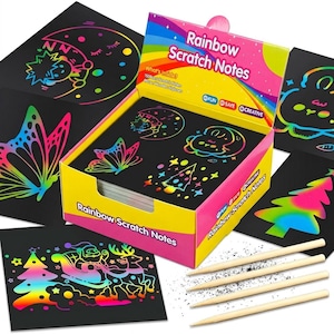 以下が含まれることがあります： Rainbow Scratch Notesと書かれた黄色とピンクの箱。セットには、蝶、月、サンタクロースなどの虹色のデザインが施された黒い紙のシートと、4本の木製スタイラスが含まれています。