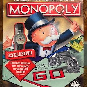 May include: A Monopoly board game box featuring Mr. Monopoly with a top hat and cane. The box includes a cutout window displaying a black-strapped wristwatch with a Mr. Monopoly face. Text on the box reads The World's Favorite Game in Live Action 3D!