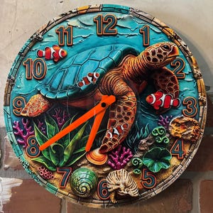 May include: A round wall clock featuring a vibrant underwater scene with a large sea turtle, several clownfish, coral, and seashells. The clock face has raised numbers from 1 to 12 in a blue font with orange outlines and bright orange clock hands.