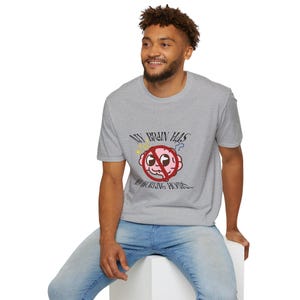 May include: A heather grey short-sleeve t-shirt featuring a graphic of a pink cartoon brain with a red prohibition circle over it. The text reads "MY BRAIN HAS NO WORKING HOURS" in a black stylised font, accompanied by small yellow stars and blue question marks.