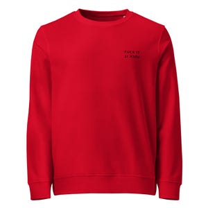 May include: A bright red long-sleeve crewneck sweatshirt featuring the text FUCK IT printed in black on the upper right chest area. The text is displayed in two lines, with the bottom line appearing in an inverted, upside-down orientation.