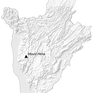 May include: A greyscale relief map of Burundi showing the country's borders and varied terrain. A small black triangle symbol marks the location of Mount Heha, with the text Mount Heha printed in black next to the symbol on the map surface.