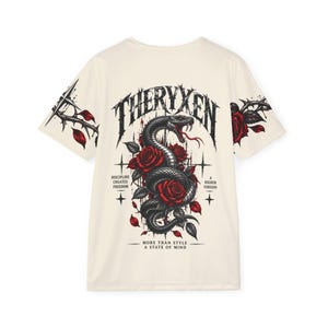 May include: An off-white t-shirt featuring a graphic of a black snake coiled around red roses. The text reads THERYXEN, DISCIPLINE CREATES FREEDOM, A HIGHER VERSION, and MORE THAN STYLE A STATE OF MIND. The sleeves feature thorny vine illustrations.