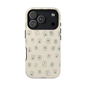May include: A cream-colored smartphone case featuring a repeating pattern of Mahjong tiles. The tiles display various characters, bamboo, and circle symbols in green, red, and black ink. The case has a black camera module cutout at the top.