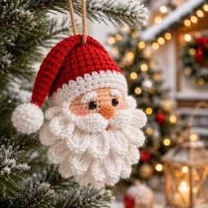 May include: A crocheted Santa Claus ornament featuring a red hat with a white pom-pom, a peach-colored face with black eyes, a small orange nose, and a thick, textured white beard made of individual crocheted loops hanging from a brown string.