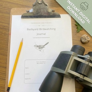 Op de afbeelding: Een wit vel papier op een bruin klembord met de titel Farmhouse and Finch's Backyard Birdwatching Journal met een vogelillustratie, een geel potlood en een zwart-grijze verrekijker. Het papier bevat velden voor naam, locatie en datum.
