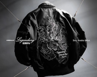 May include: A black boxy bomber jacket featuring a white line-art graphic on the back depicting a dragon and a tiger. The text "KREMLIN", "Legendary", "伝説的な", "Legendary Tora to Ryu", and "Boxy Bomber Jacket" are printed on the garment.