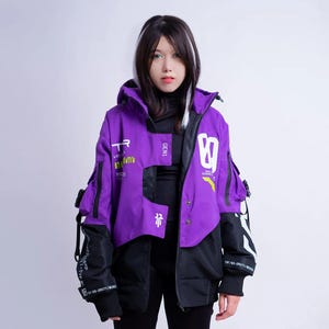 May include: A purple and black hooded jacket featuring white graphic text and symbols, including the number 89, the word GEN1, and various technical markings. The jacket has long sleeves with black ribbed cuffs, multiple pockets, and adjustable straps.