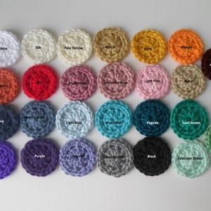 May include: A collection of 24 crocheted circles in various colors, including white, silk, pale yellow, maize, gold, mango, pumpkin, red, plum wine, Victorian rose, light pink, bone, navy, country blue, light blue, blue mint, pagoda, cool green, sage, iris, purple, lavender, grey heather, black, and seafoam green.
