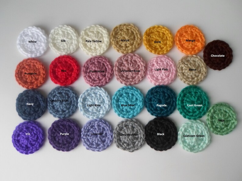 May include: A collection of 24 crocheted circles in various colors, including white, silk, pale yellow, maize, gold, mango, pumpkin, red, plum wine, Victorian rose, light pink, bone, navy, country blue, light blue, blue mint, pagoda, cool green, sage, iris, purple, lavender, grey heather, black, and seafoam green.