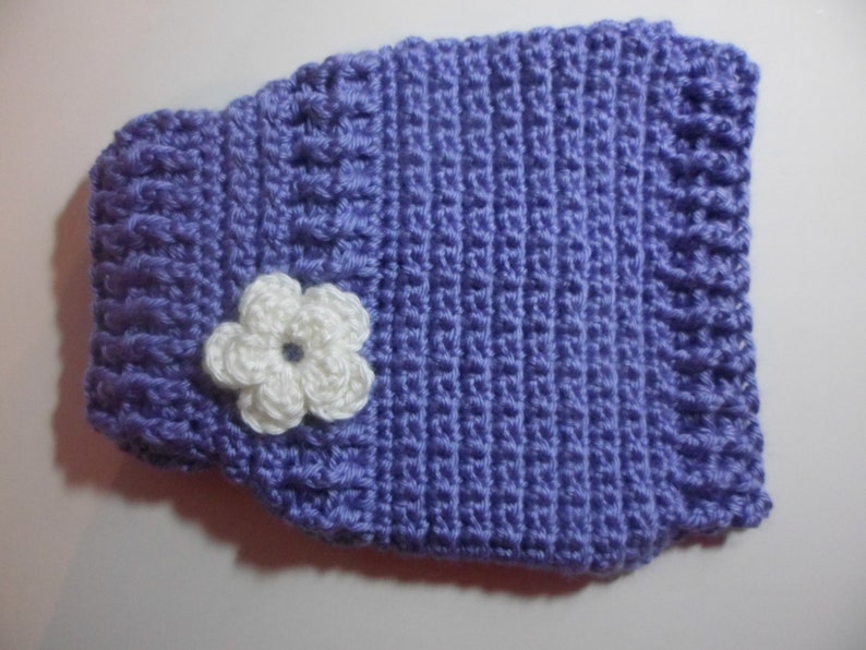 May include: A purple crocheted vest with a white crocheted flower.