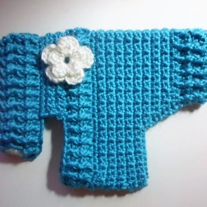 May include: A blue crocheted sweater with a white crocheted flower on the front.
