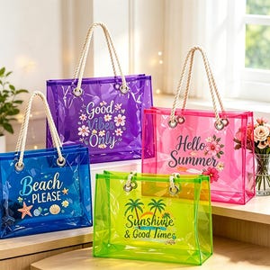 Puede incluir: Cuatro bolsos rectangulares transparentes con asas de cuerda. El bolso azul dice Beach Please con estrellas de mar y conchas. El morado dice Good Vibes Only con flores. El rosa dice Hello Summer con flores. El verde dice Sunshine & Good Times con palmeras.