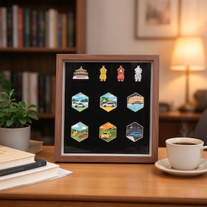 May include: A square wooden display case with a black interior backing, featuring nine enamel pins arranged in three rows. The top row contains four character pins, while the bottom two rows feature six hexagonal pins depicting various cars in landscapes.