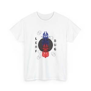May include: A white short-sleeved t-shirt featuring a central graphic of a blue and red insect silhouette layered over a dark grey circle. The text LEAF BUG is printed vertically in black on either side of the circle, accompanied by thin lines.