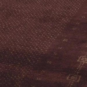 May include: A deep burgundy rug featuring a dense pattern of small, light-colored dots across the main surface, contrasted by a distinct border section decorated with a repeating series of square geometric motifs in a lighter shade.