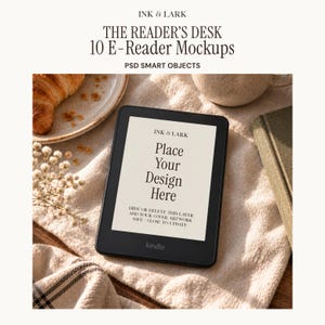 Könnte beinhalten: Ein schwarzes E-Reader-Gerät mit einem Bildschirm, der den Text INK & LARK Place Your Design Here, HIDE OR DELETE THIS LAYER ADD YOUR COVER ARTWORK SAVE - CLOSE TO UPDATE anzeigt. Das Gerät liegt auf einer strukturierten Stoffoberfläche neben einem Croissant.