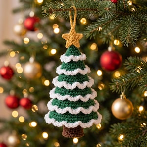 May include: A crocheted Christmas tree ornament featuring a dark green cone-shaped body with white ruffled trim on each tier. The top is adorned with a yellow crocheted star and a matching loop for hanging, while the base is brown.