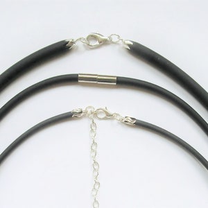 May include: Three black silicone necklace cords with silver clasps and a silver chain. The cords are different lengths.