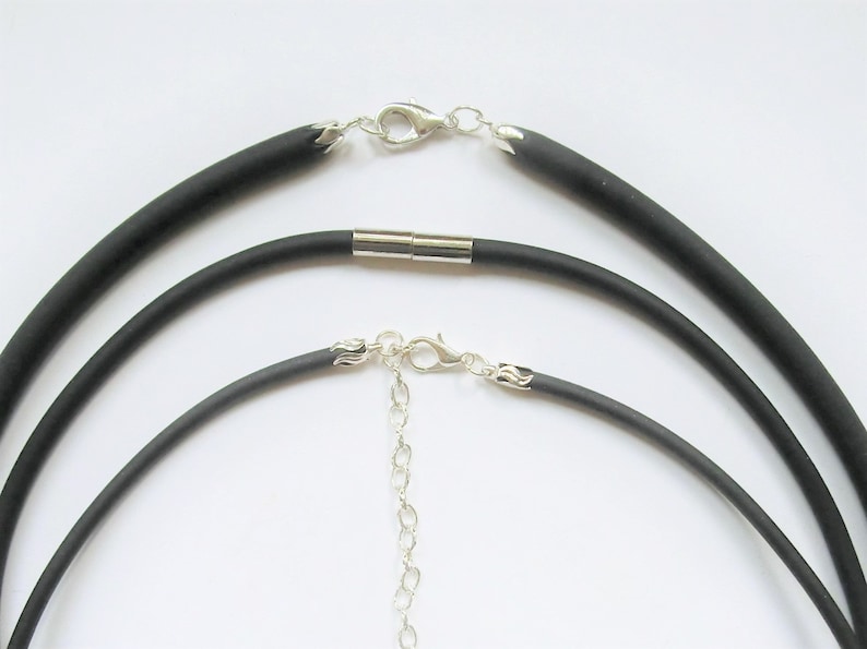 May include: Three black silicone necklace cords with silver clasps and a silver chain. The cords are different lengths.