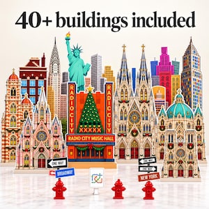 May include: A collection of over 40 miniature cardboard buildings featuring iconic New York City landmarks like Radio City Music Hall, the Statue of Liberty, and various cathedrals, accompanied by street signs and red fire hydrants.