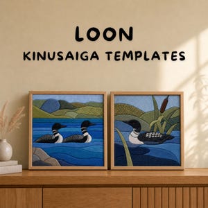 May include: Two framed Kinusaiga fabric art panels featuring loons on water with hills in the background. The text LOON KINUS AIGA TEMPLATES is displayed above the square wooden frames, which depict blue water, green hills, and cattails.